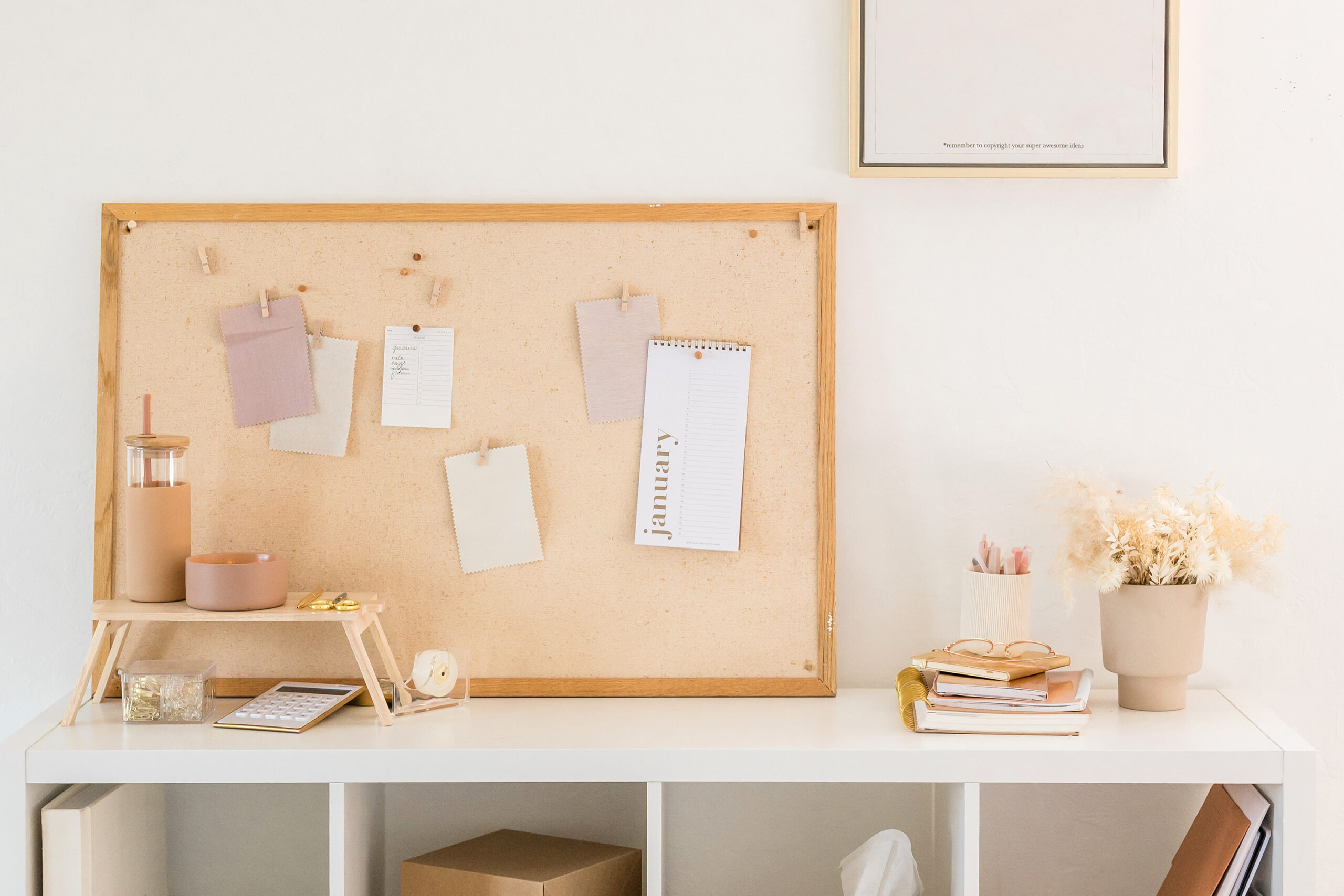 an organized desk with a cork board