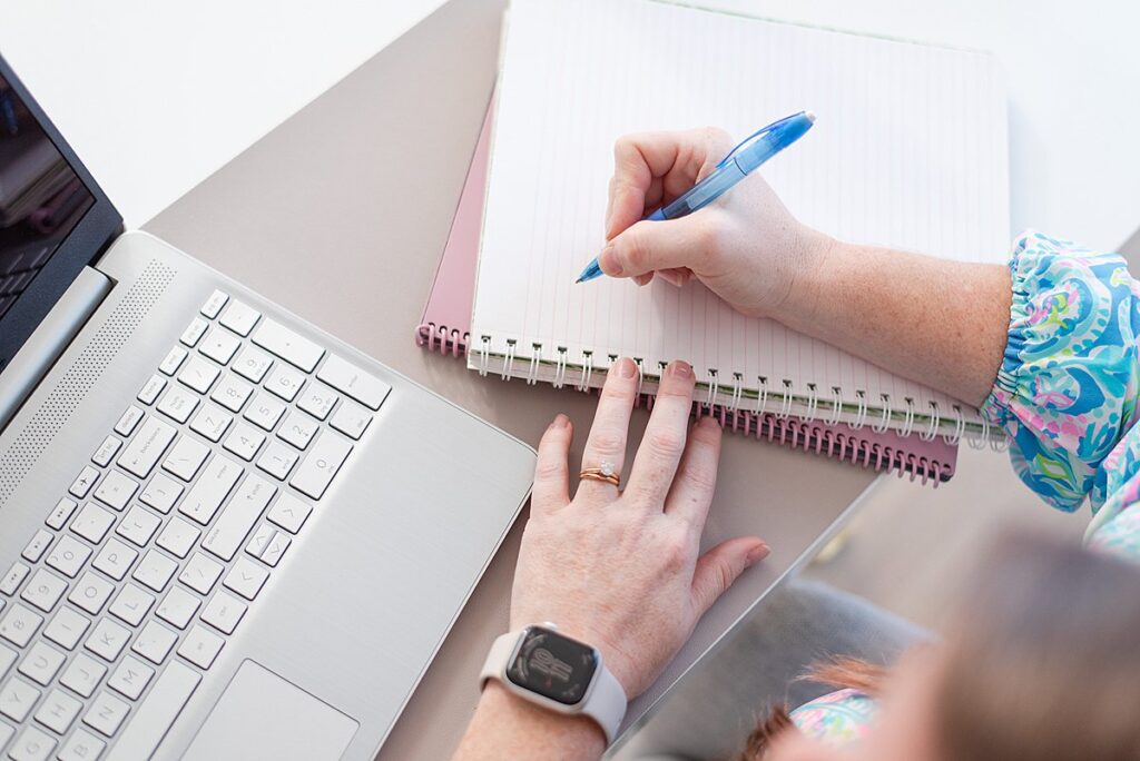 image of melissa arlena at her desk with her computer and a notebook