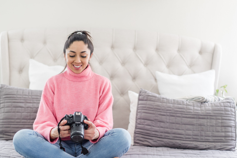 a photographer stares at her camera thinking about search engine optimization for photographers