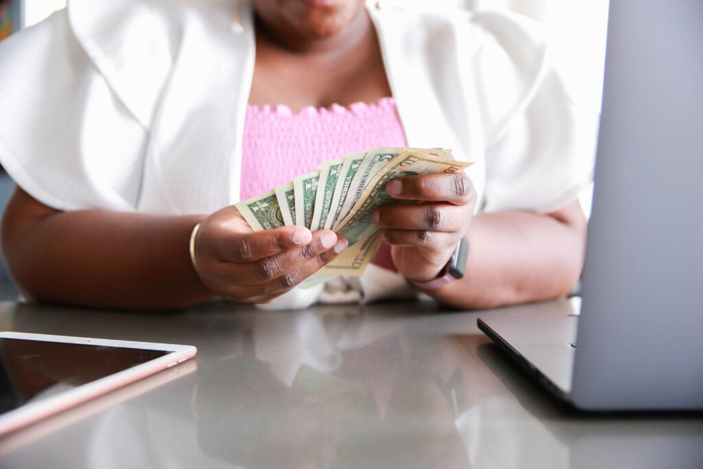 photographer counts money looking at her computer learning how to make money as a photographer when business is slow