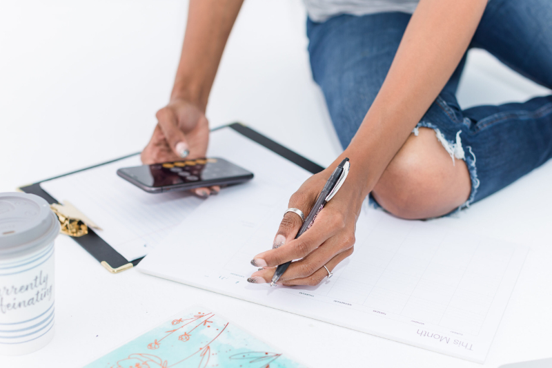 a photographer sits on the floor mapping out her photography marketing plan